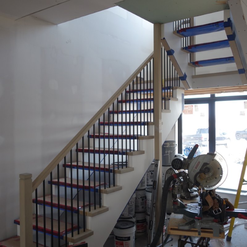open riser stair under construction showing rise, run, and baluster spacing